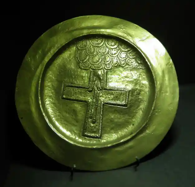 Cross inside a circle on a gold plate